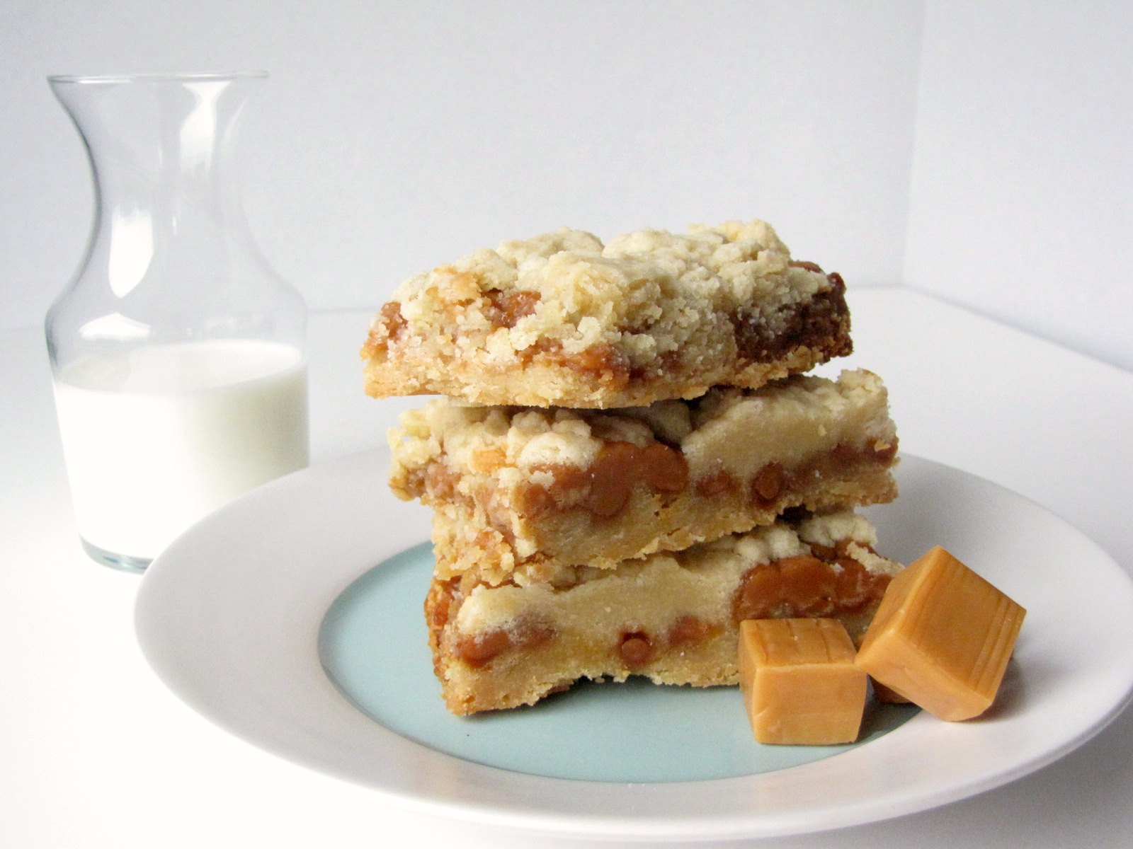 Slow Cooker Salted Caramel Cookie Bars on a plate with caramels and milk