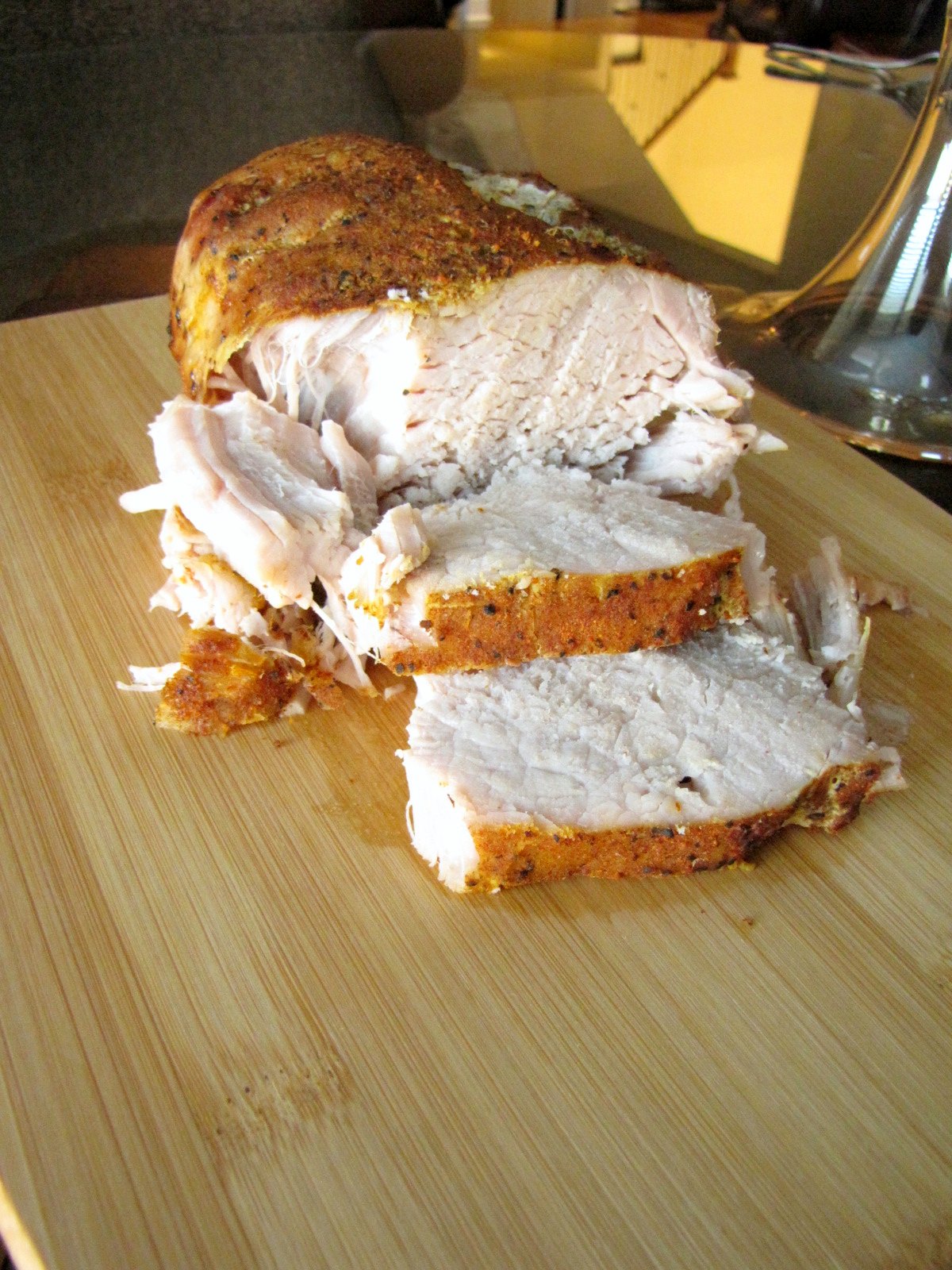 Sweet and Spicy Pork Roast on carving board with two slices.