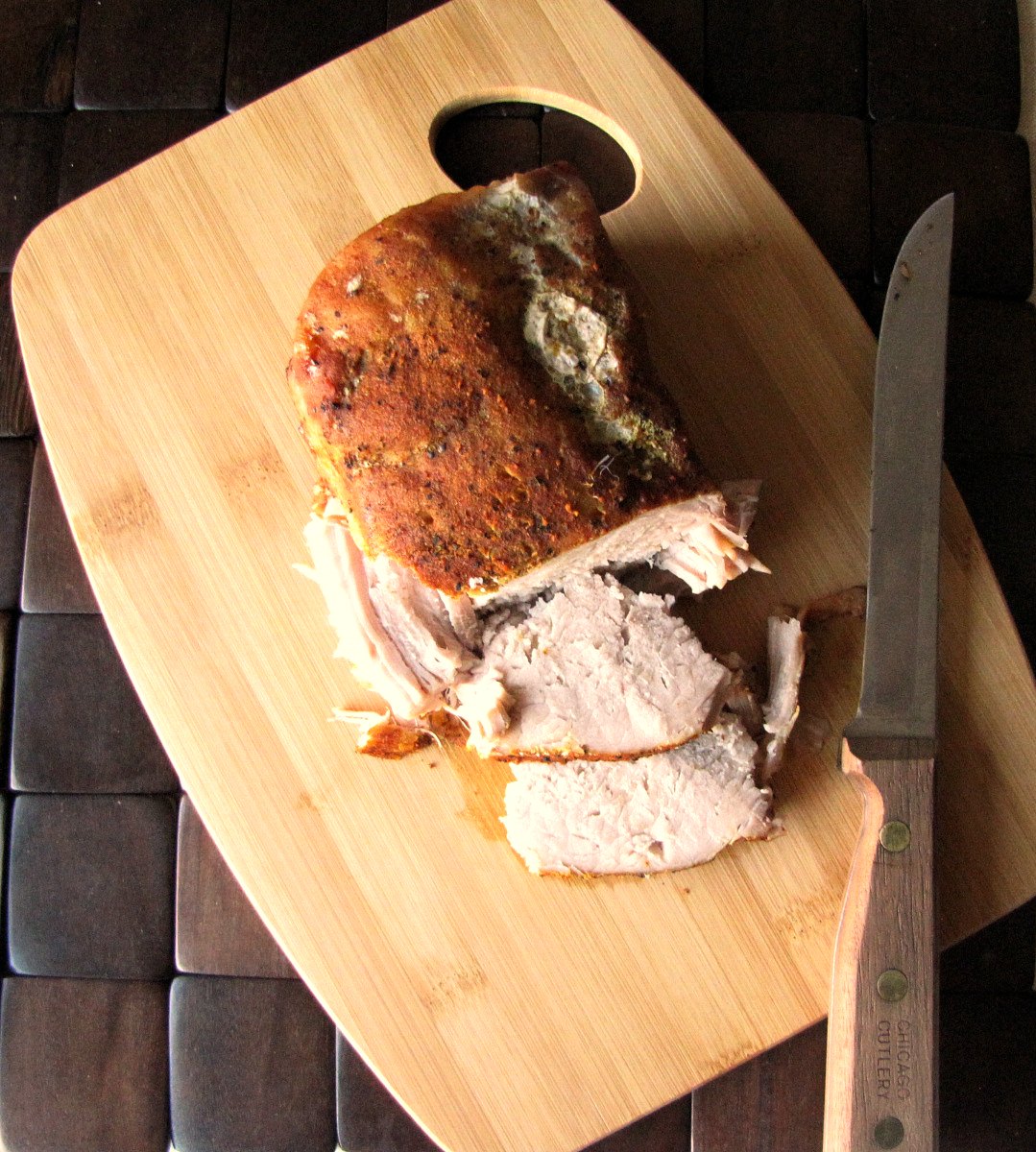 pork roast on carving board, knife and two slices