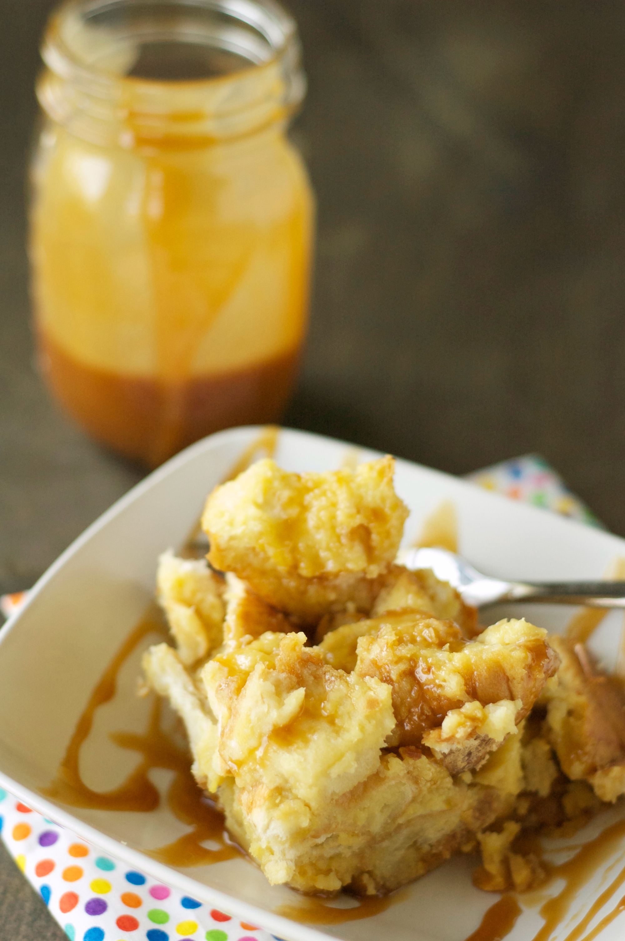 Slow Cooker Bread Pudding drizzled with Salted Caramel Sauce in white bowl on polka dot napkin