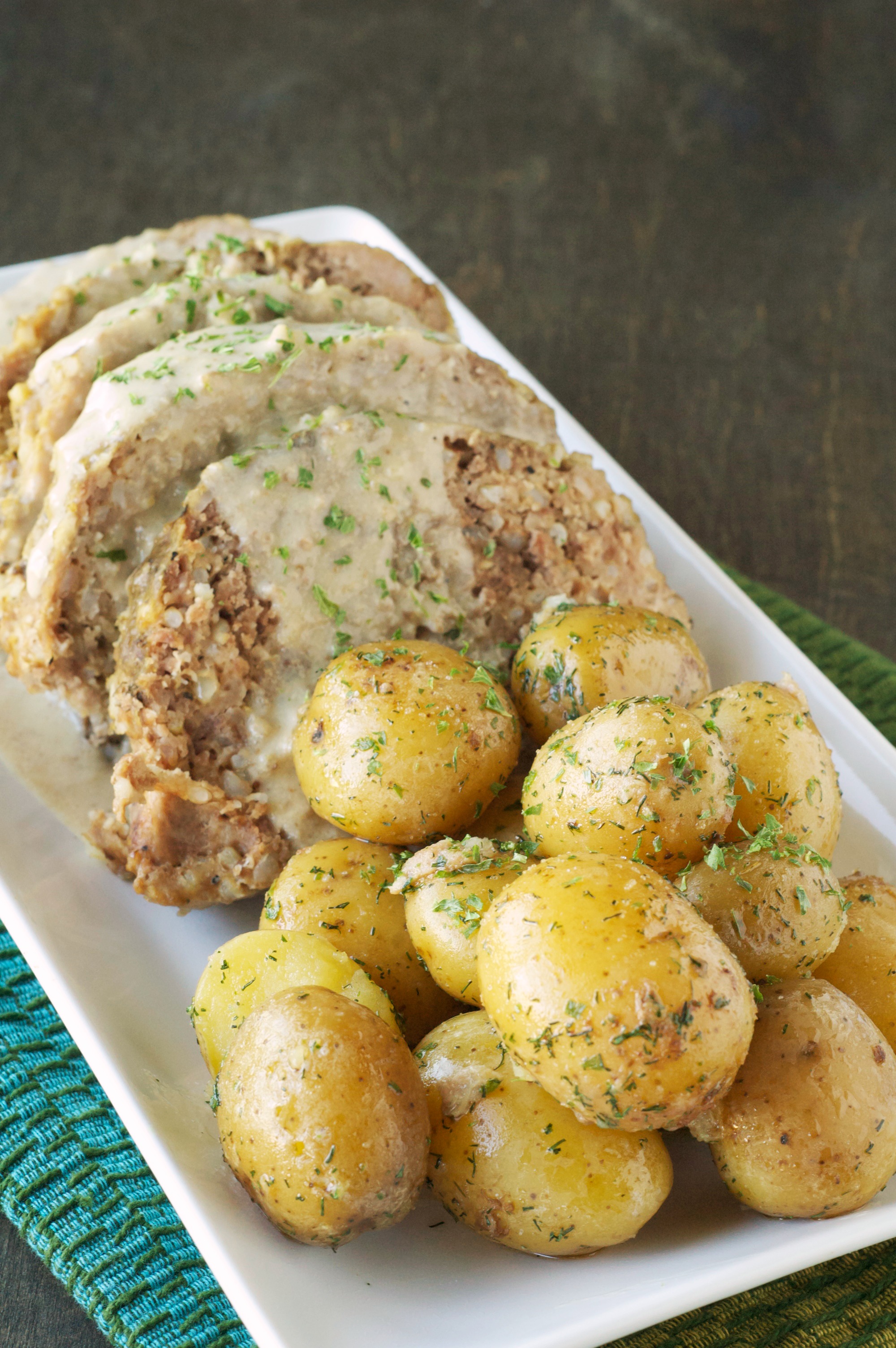 Four pieces of Creamy Meatloaf with Baby Dill Potatoes on long white platter