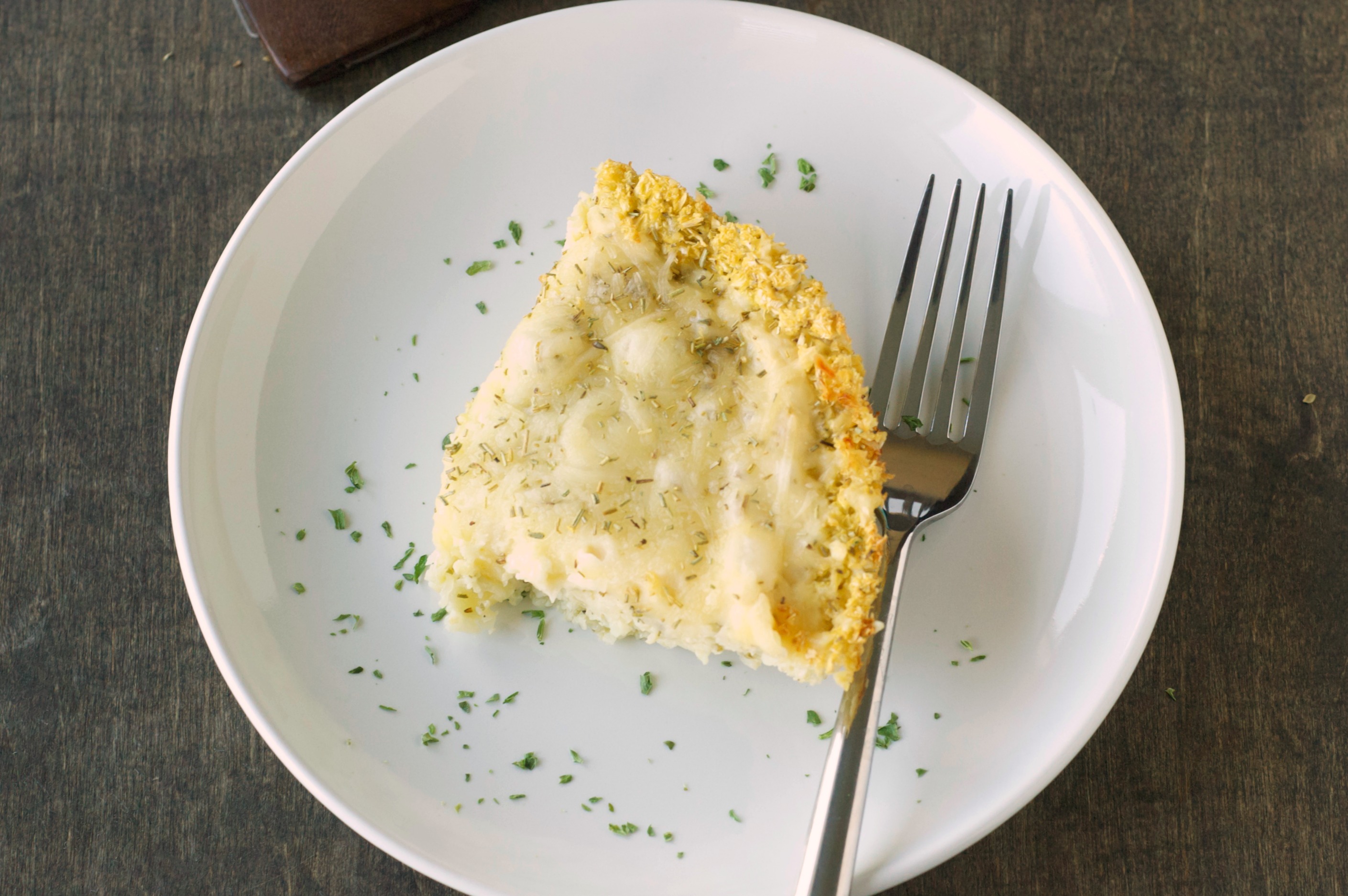 top view of deep dish pizza on white plate with fork