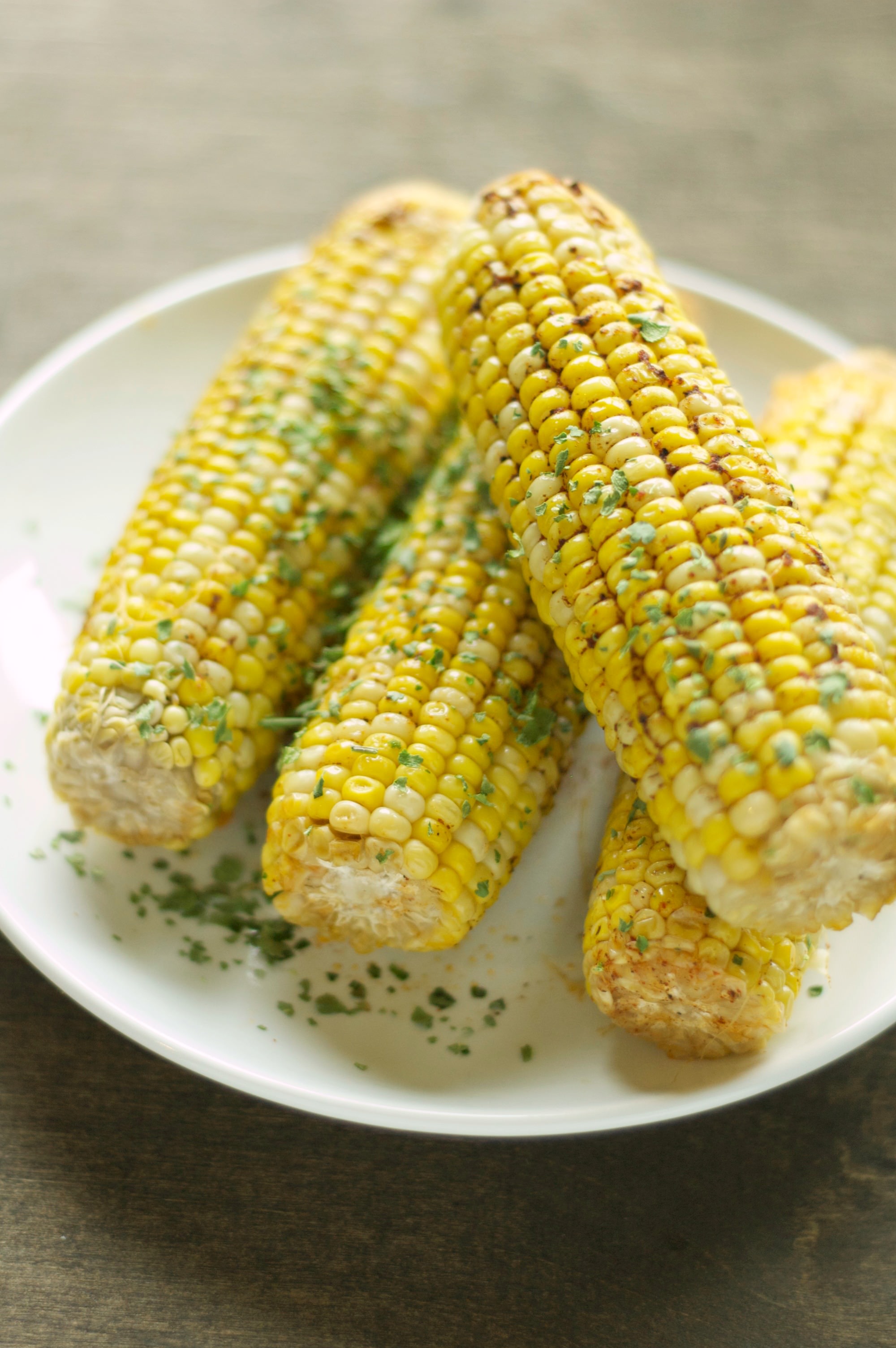 four pieces of corn on the cob on white plate