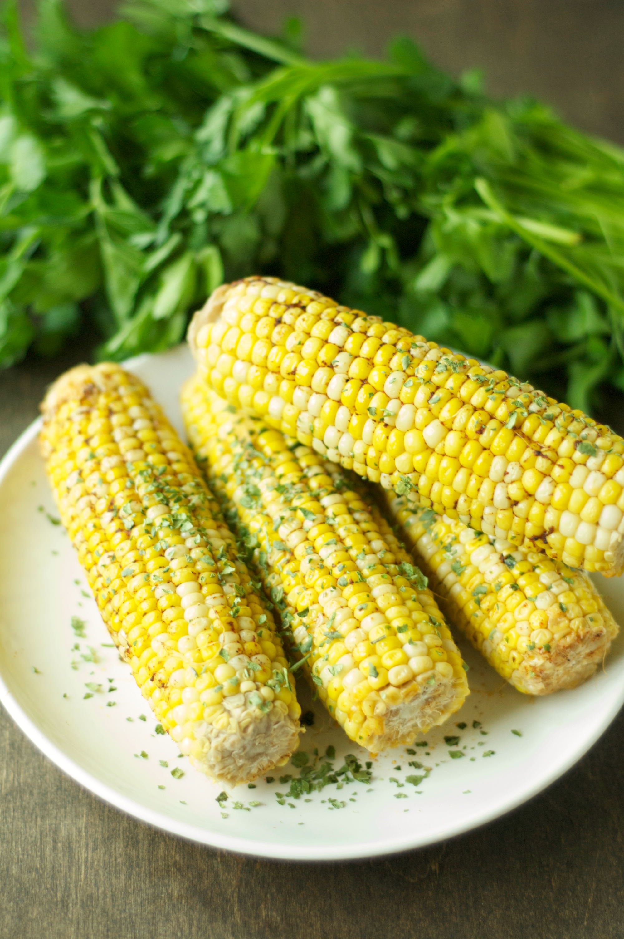 four pieces of corn on the cob on white plate