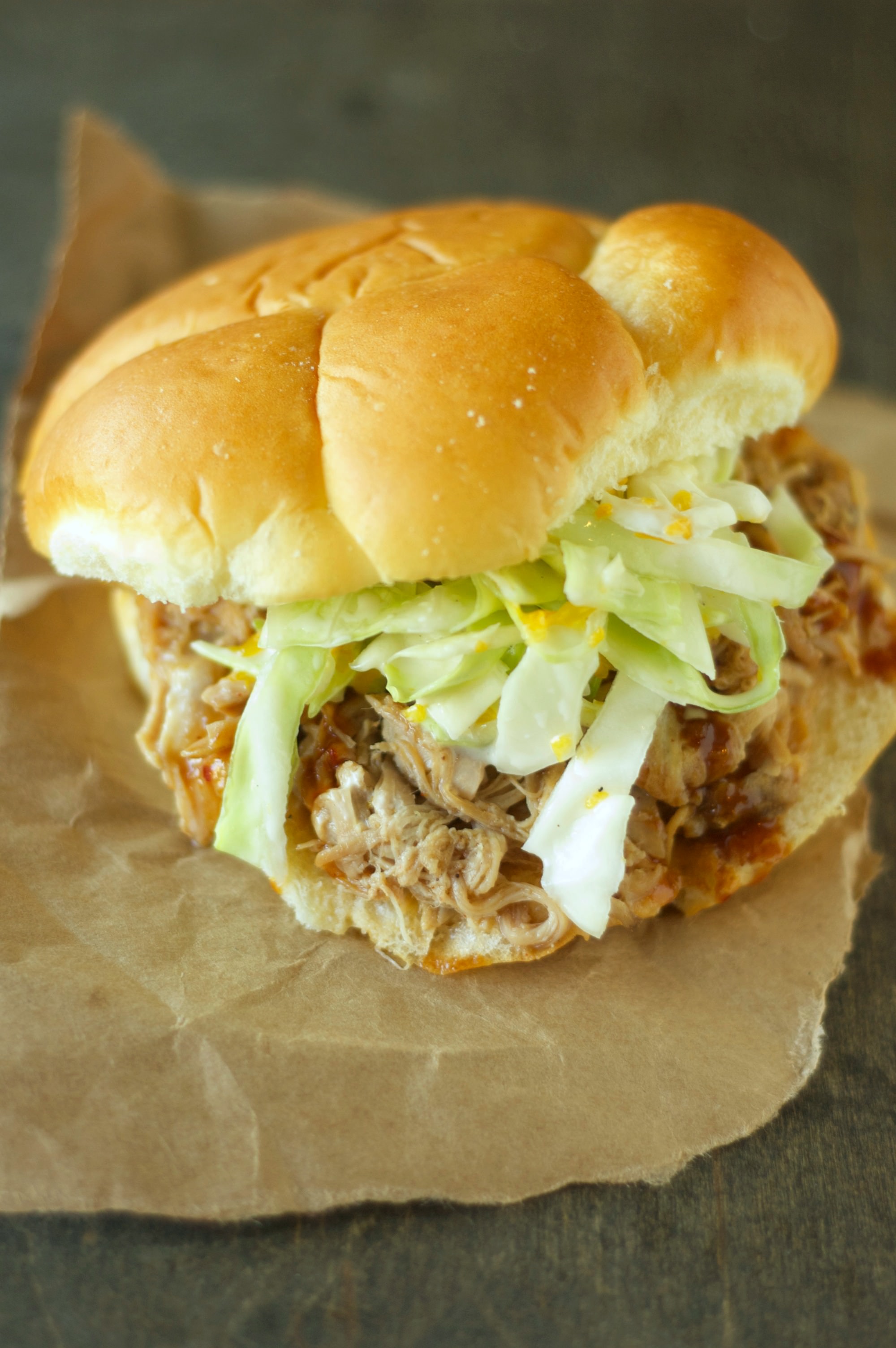 Slow Cooker Pulled Pork sandwich on a bun with slaw on top