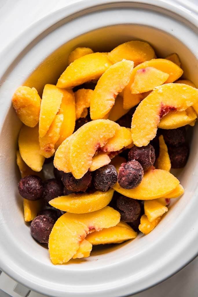 frozen sliced peaches and cherries in a casserole slow cooker
