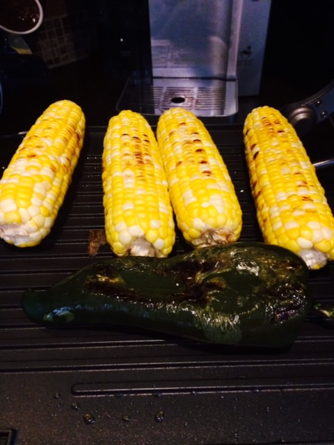 Four ears of roasted corn and poblano pepper on grill