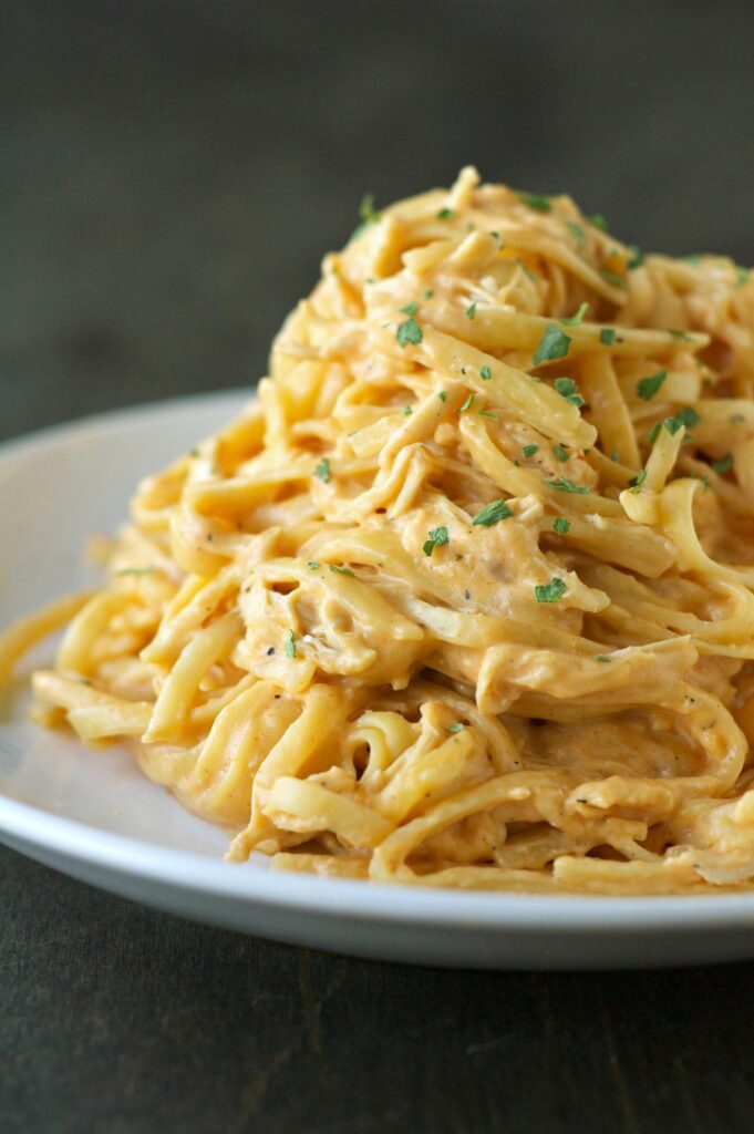 white plate filled with mound of cheesy buffalo chicken pasta