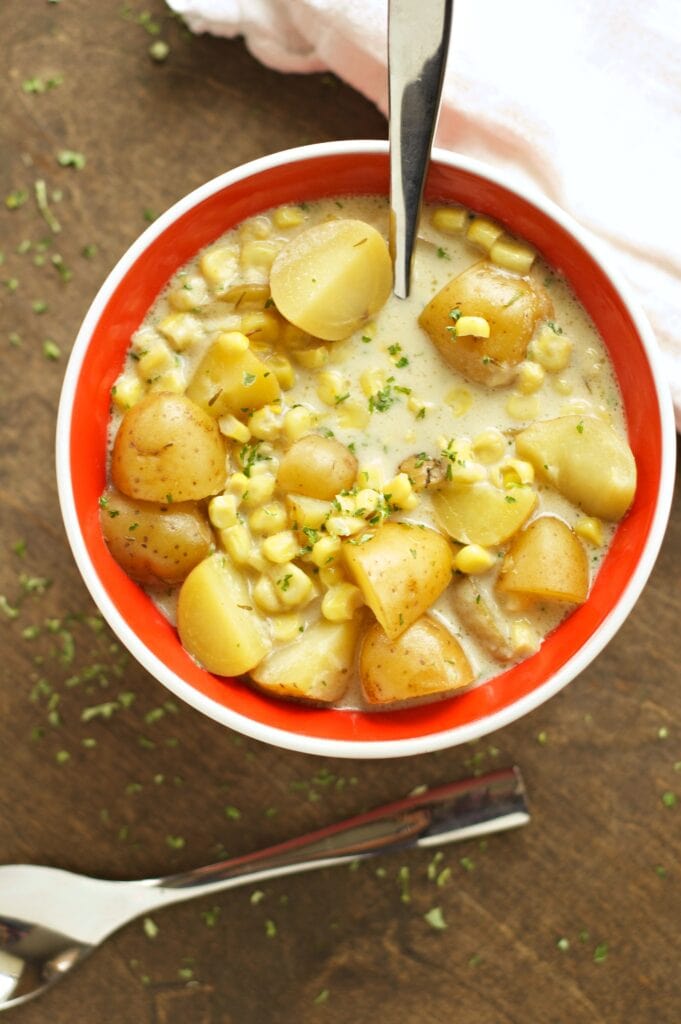 Slow Cooker Corn and Potato Chowder in red bowl with spoon