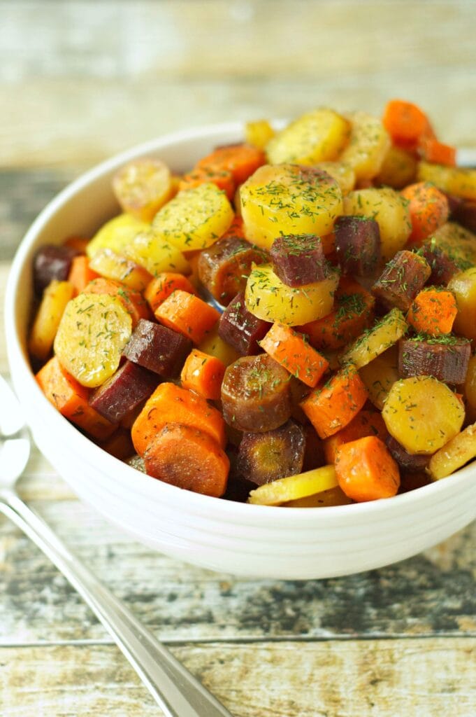 Slow Cooker Carrots with Honey Butter Sauce in white bowl with dill sprinkle
