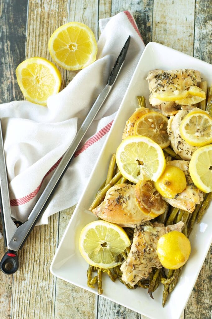 Slow Cooker Lemon Pepper Chicken and Asparagus in white platter with lemon slices
