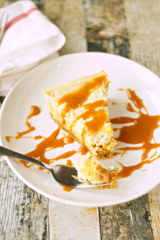 Slice of Slow Cooker Browned Butter Pumpkin Cheesecake o white plate with fork