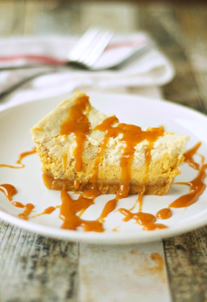 Slice of Slow Cooker Browned Butter Pumpkin Cheesecake with fork in background