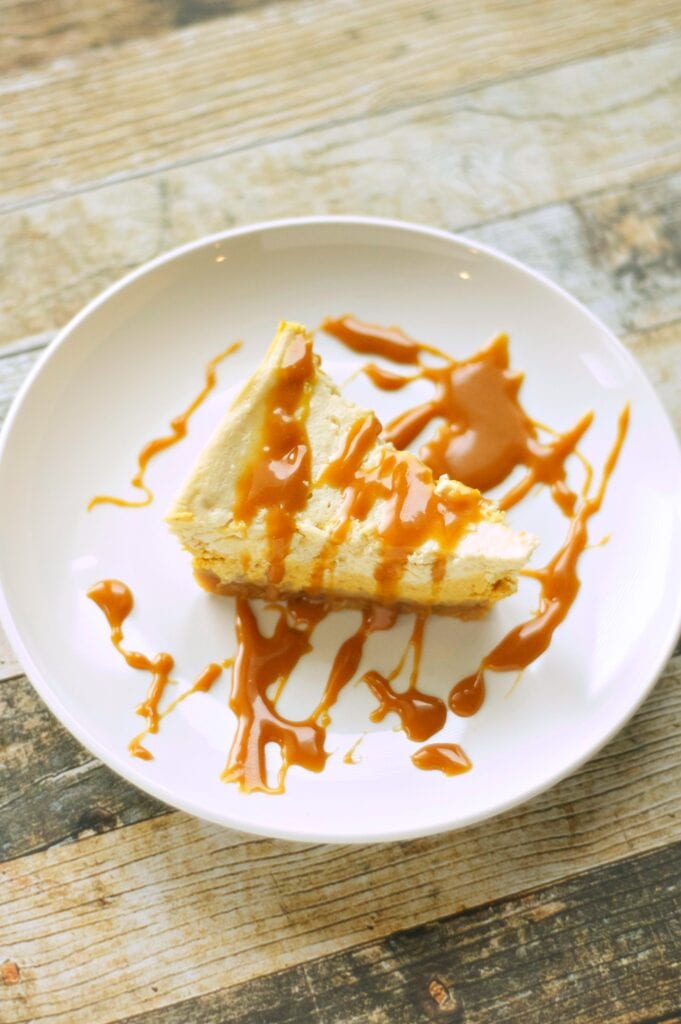 Slice of Slow Cooker Browned Butter Pumpkin Cheesecake on white plate