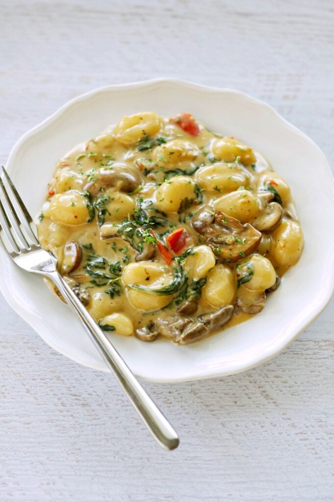 Creamy White Cheddar Skillet Gnocchi in white bowl with fork