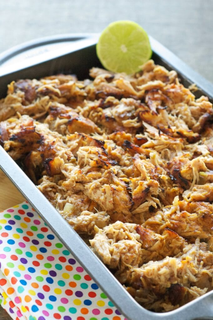 carnitas in 13x9 pan with lime slice