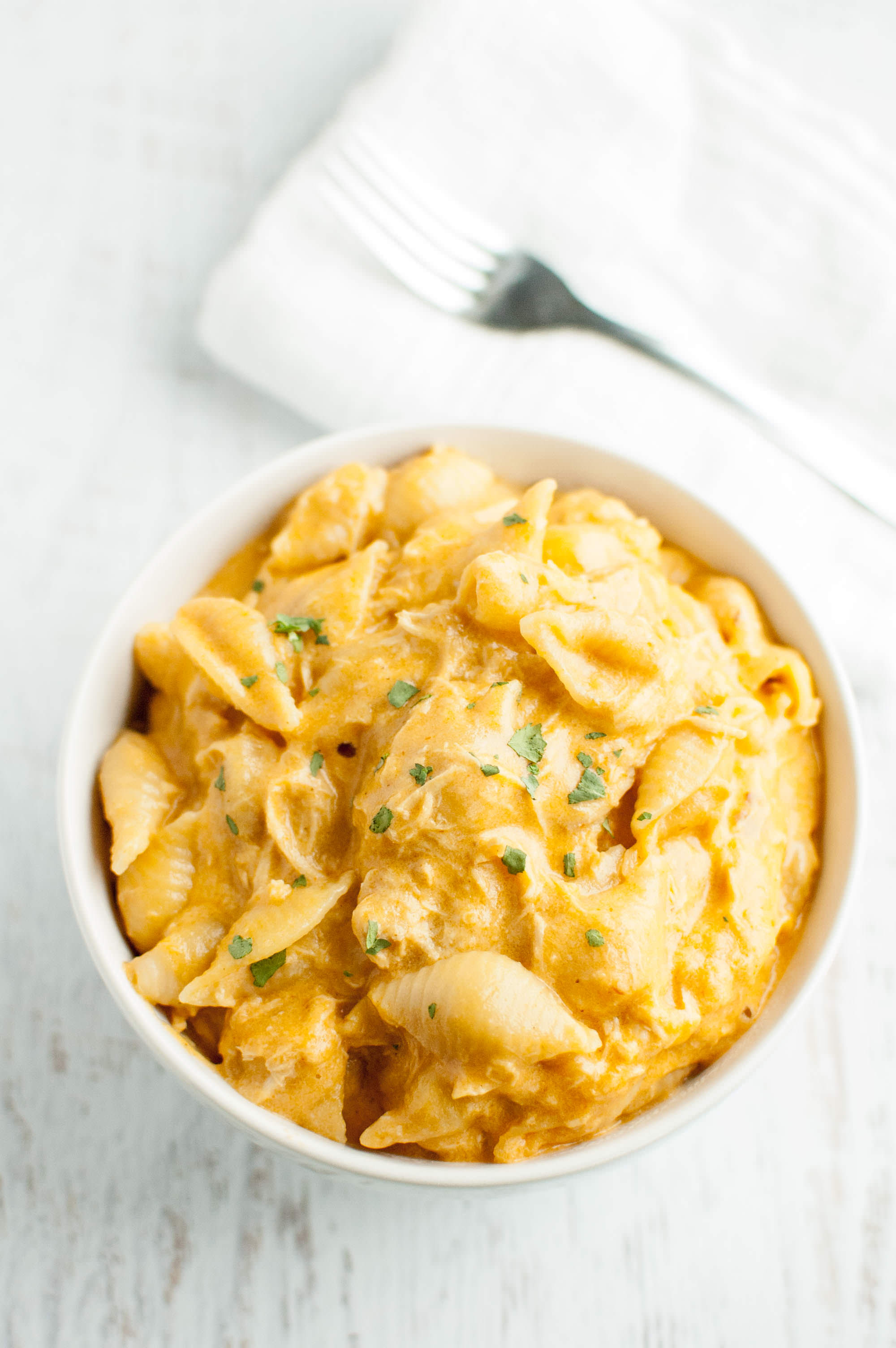 Slow Cooker Buffalo Chicken Mac and Cheese in white bowl with fork and napkin on side