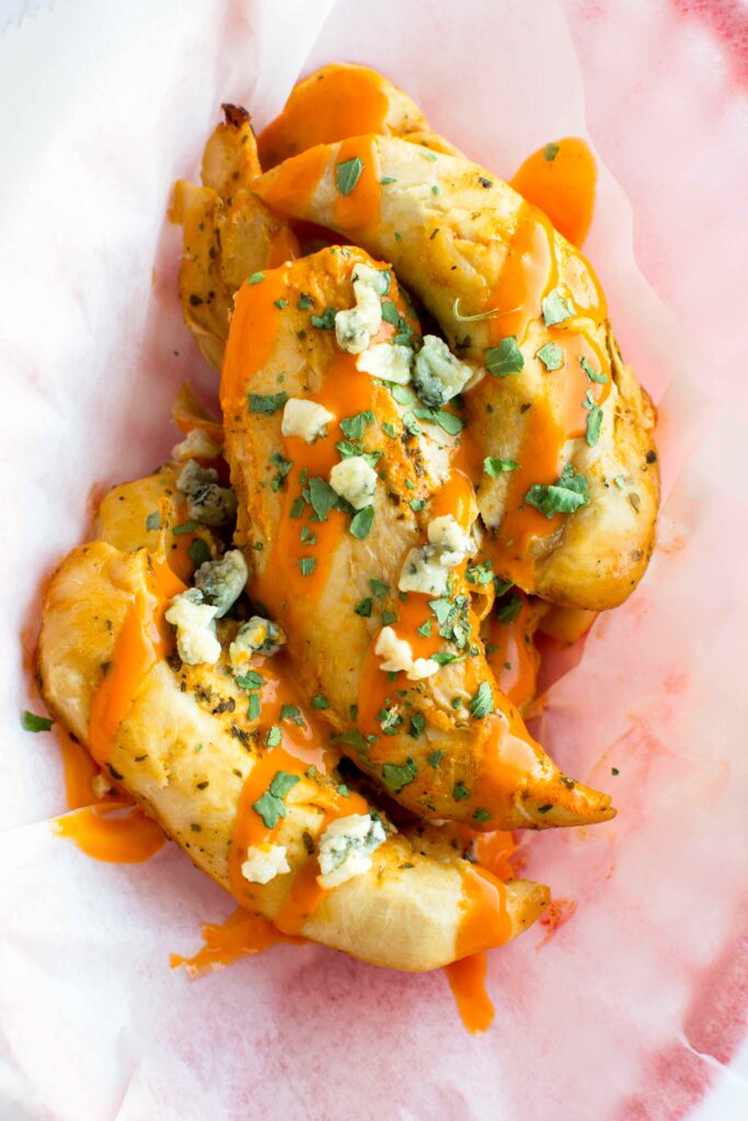 Slow Cooker Ranch Buffalo Chicken Tenders in basket with parchment paper