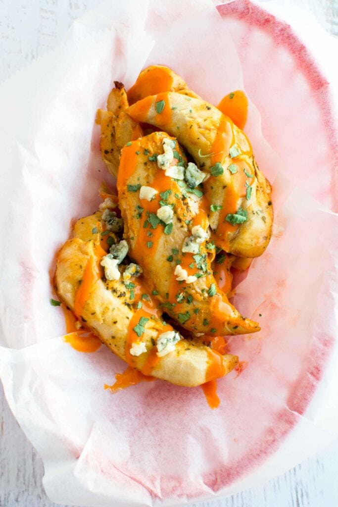 Slow Cooker Ranch Buffalo Chicken Tenders in basket with parchment paper