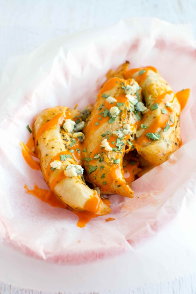 Slow Cooker Ranch Buffalo Chicken Tenders in basket with parchment paper