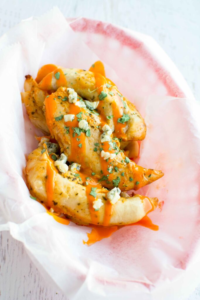 Slow Cooker Ranch Buffalo Chicken Tenders in basket with parchment paper