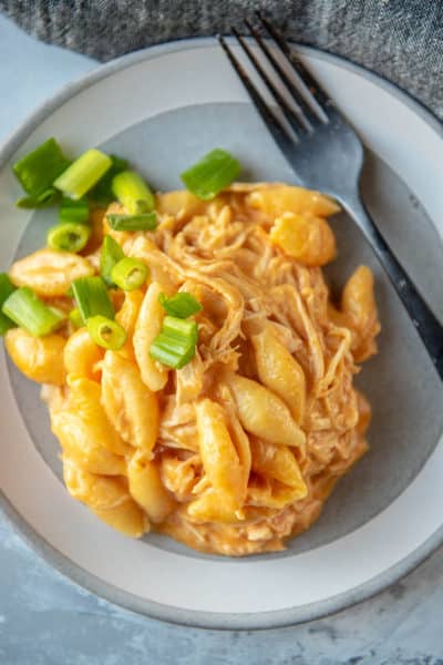 buffalo chicken topped with green onions on a gray and white plate