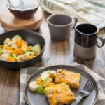 Slow Cooker Easy Breakfast Casserole served on a black plate wtih coffee and fruit.