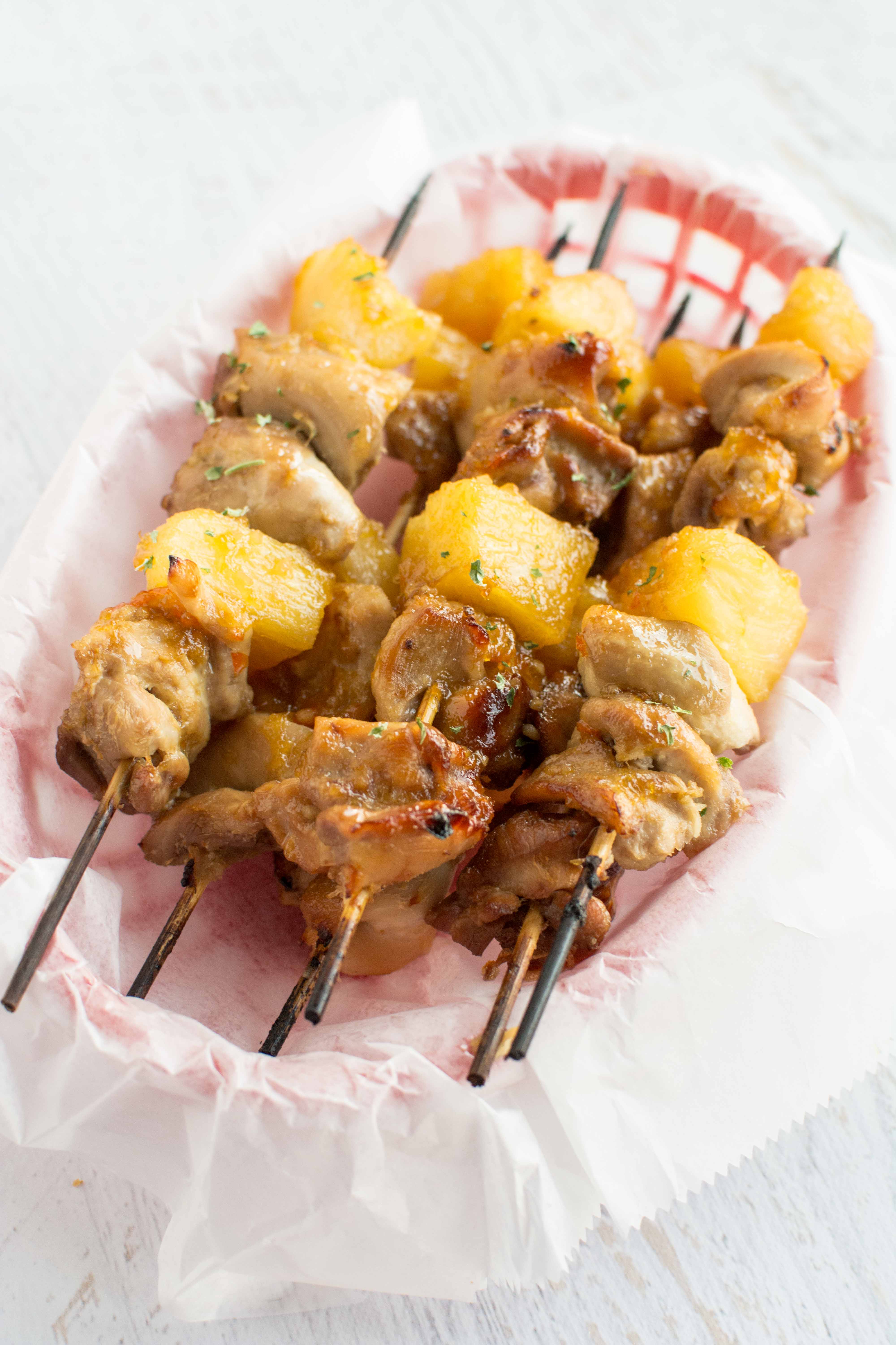 slow cooker chicken skewers in parchment paper lined red basket
