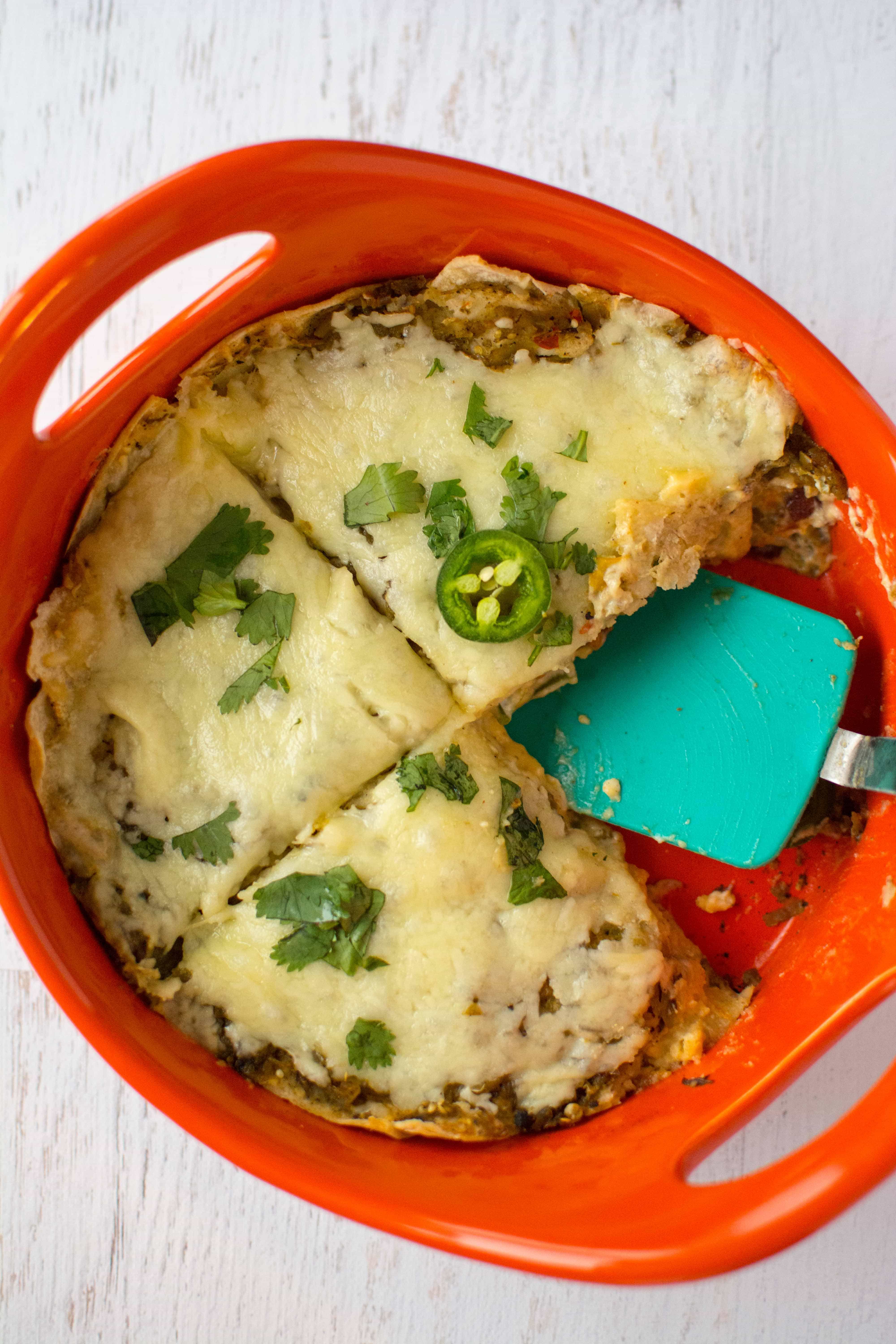Jalapeno Popper Enchilada Pie in red baking dish with spatula