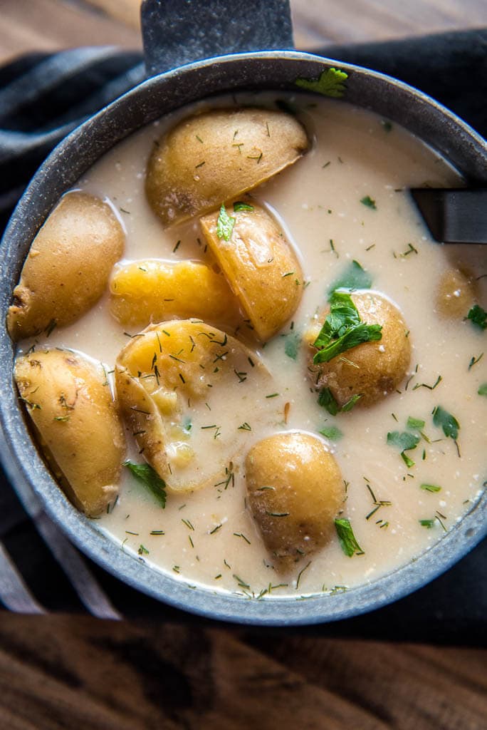 Slow Cooker Skinny Potato Soup in metal bowl with black napkin and spoon