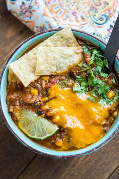 Slow Cooker Taco Soup is a family favorite dinner that has just a few ingredients and can be made in minutes. My secret ingredients makes it the best taco soup out there for flavor and richness!