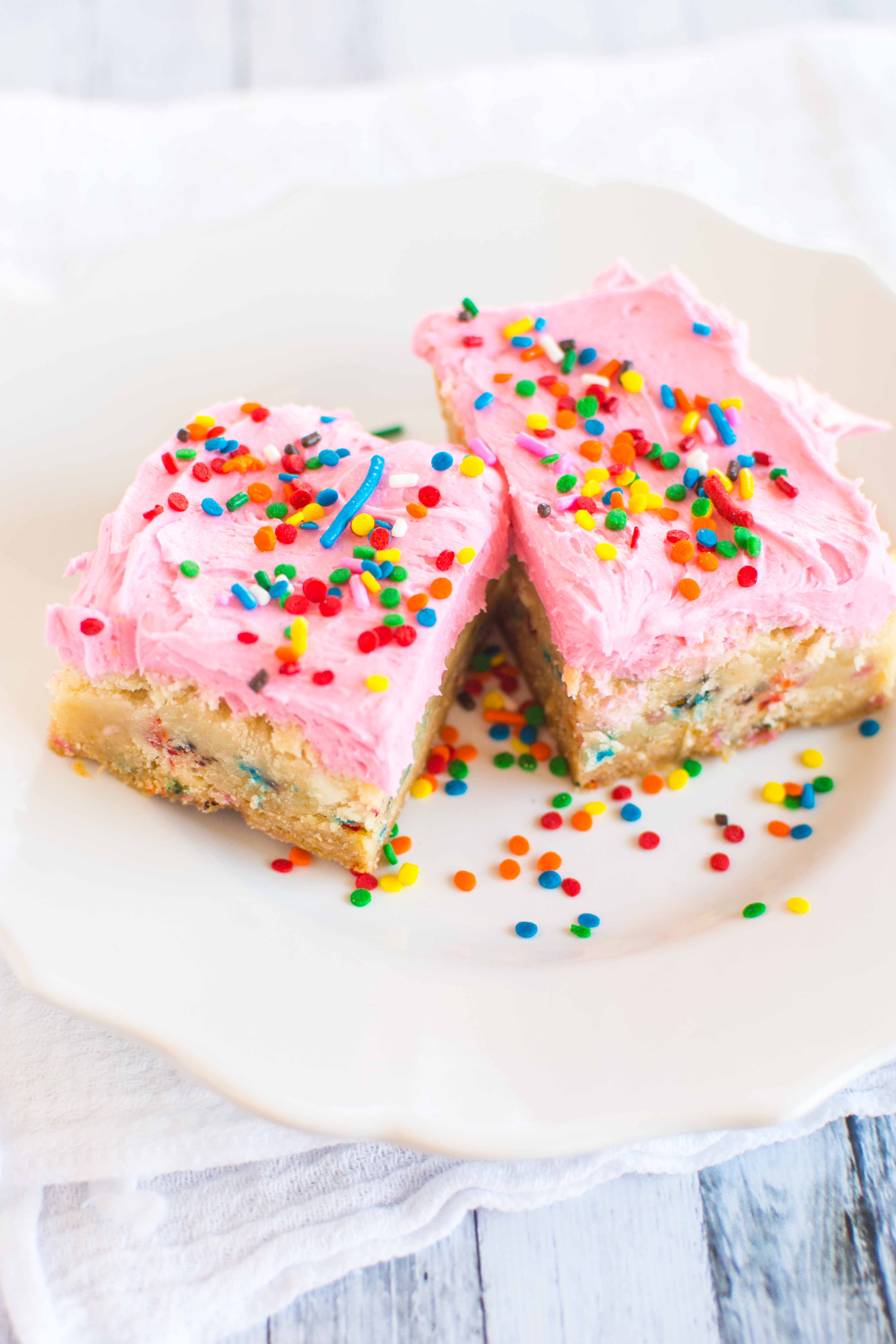 two cookie bars on white plate with sprinkles