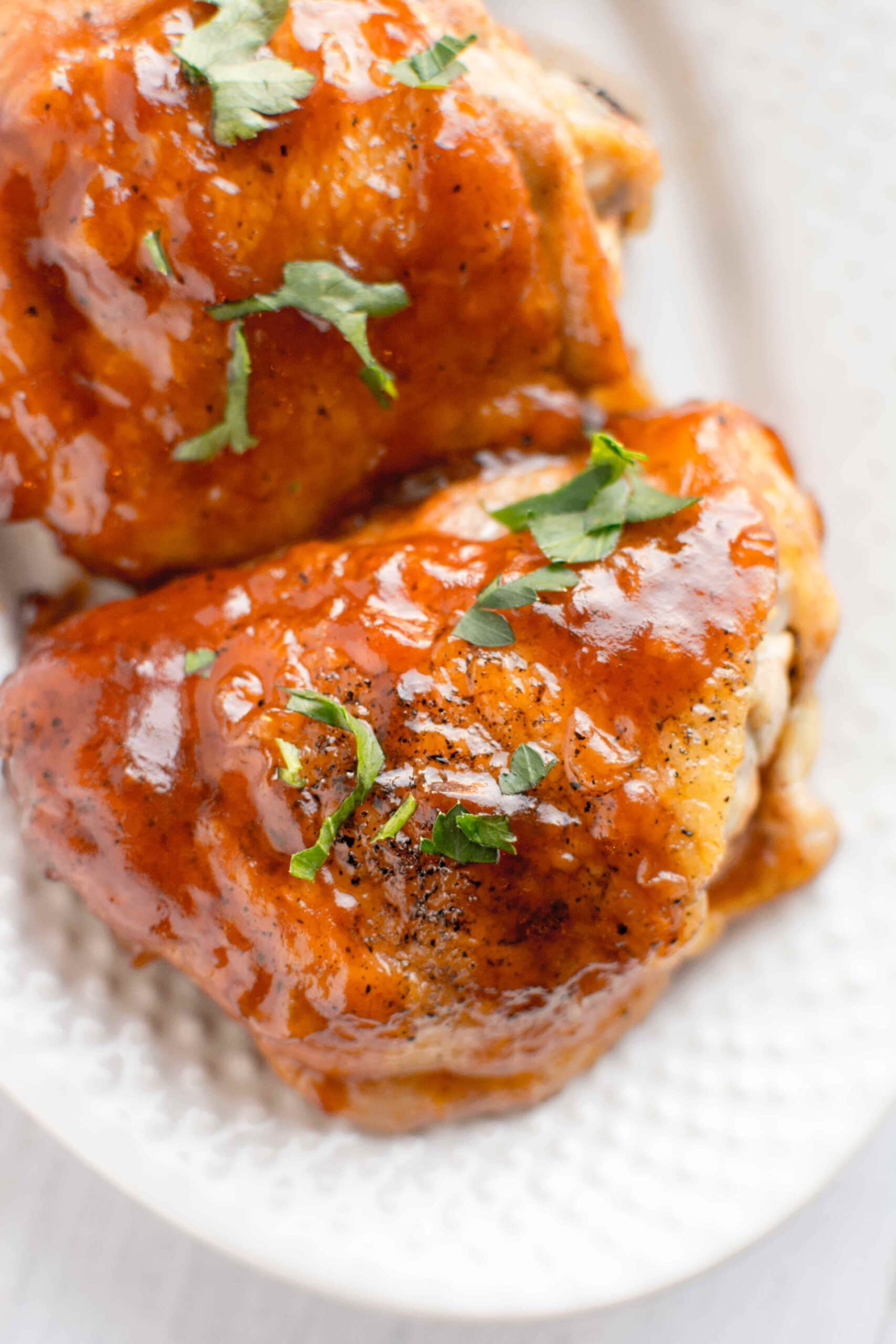 white plate with two pieces of honey chipotle bbq chicken