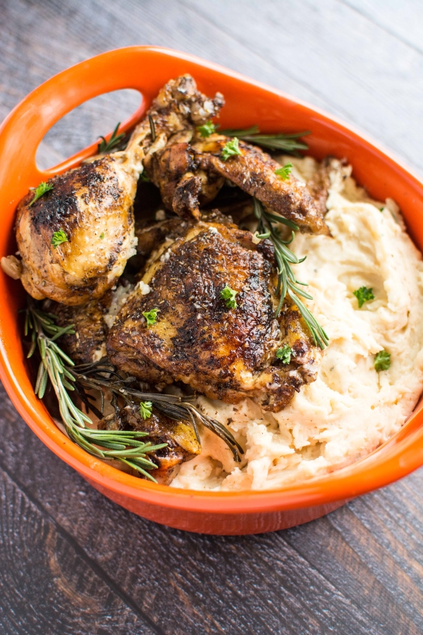 rosemary balsamic chicken and mashed potatoes in orange serving bowl with rosemary sprigs on top
