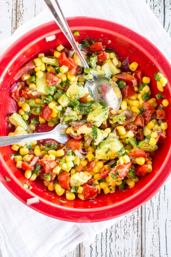 large red bowl with corn and avocado salsa with spoon and fork 