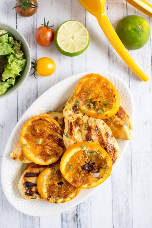 grilled bbq chicken on plate with citrus and a side salad