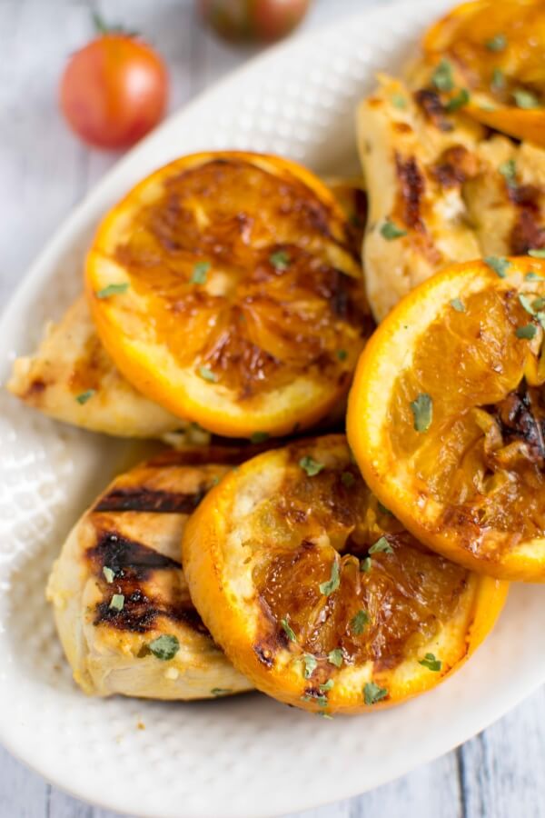 grilled bbq chicken with grilled oranges on a white platter