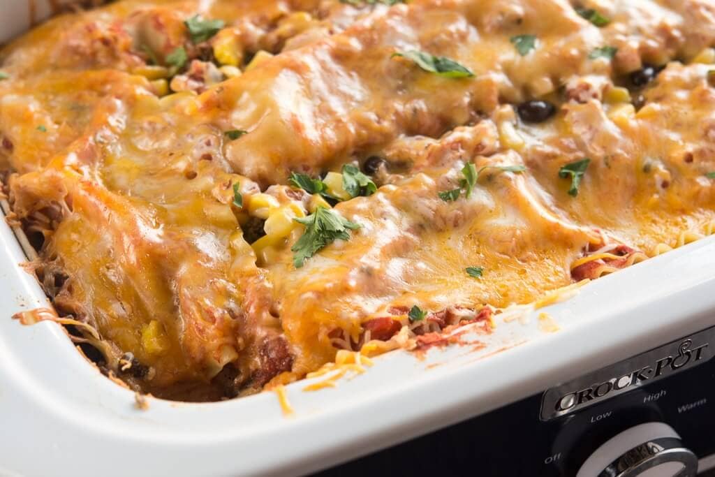 Slow Cooker Mexican Lasagna topped with melted cheese in a casserole slow cooker.