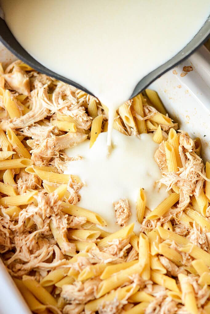 Pouring cheese sauce over pasta - Slow Cooker Chicken White Cheddar Bacon Mac