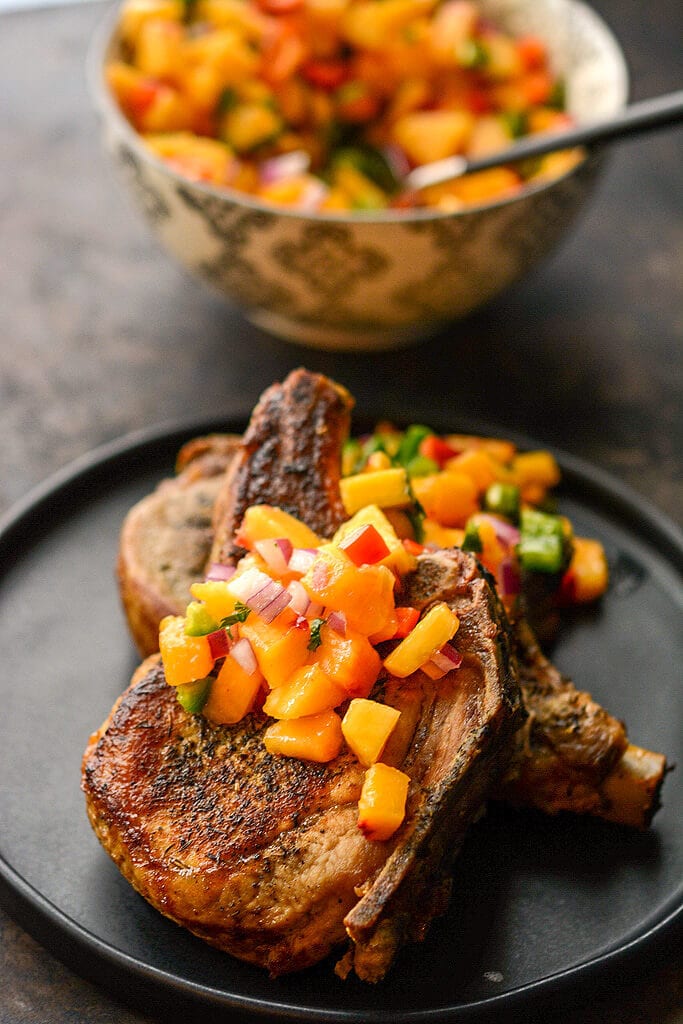 These bone in pork chops are easy to make in your slow cooker and you wouldn't believe how simple it is to make the healthy peach salsa!alt=