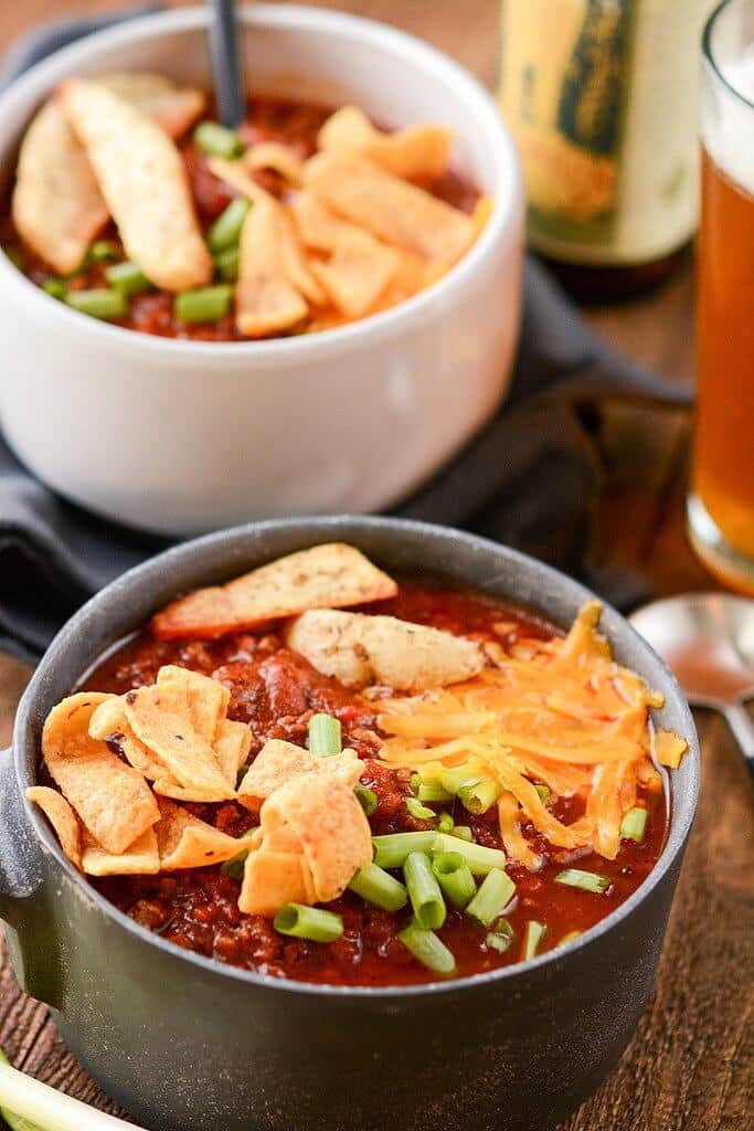 Slow Cooker Tailgate Chili in a metal bowl served with a cold beer