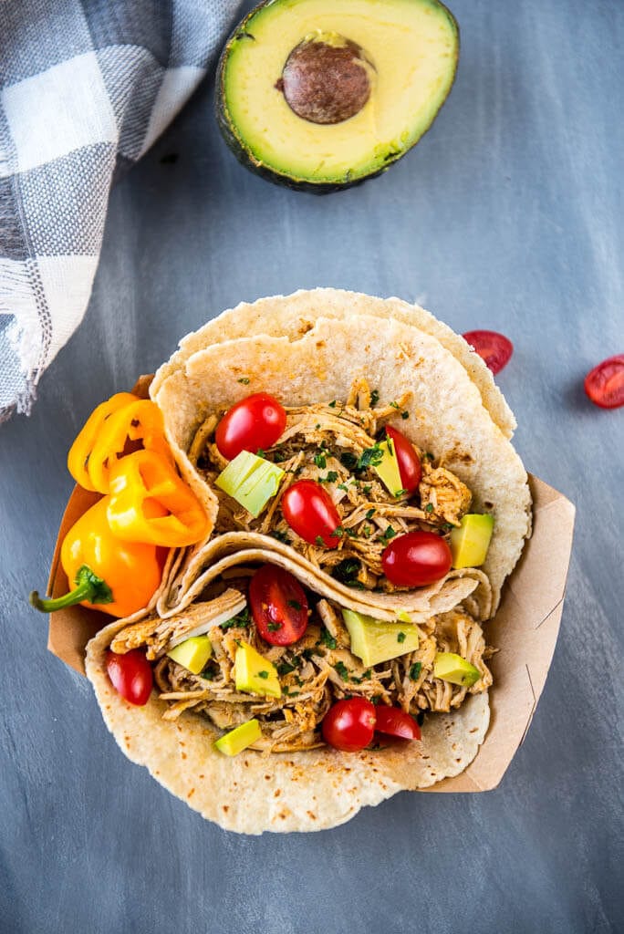 Slow Cooker Verde Chicken Tacos are the easiest family dinner you will make this week! Only 5 ingredients plus all your favorite taco toppings!
