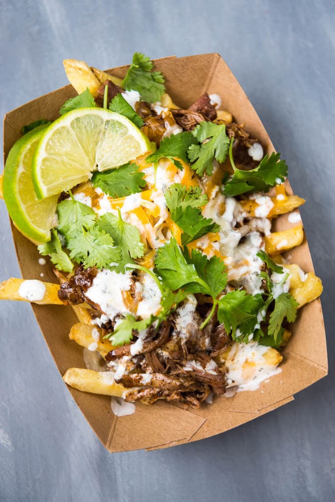 Top view of Slow Cooker Enchilada Chili Cheese Street Fries in paper container