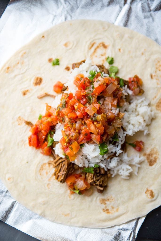 Slow Cooker Barbacoa Burritos are the easy alternative to take-out. A perfect summer family meal all wrapped up!