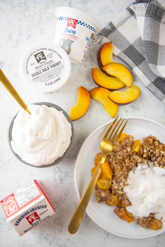 Looking for a delicious treat to use all those farmer's market fresh peaches? Slow Cooker Peach Cobbler with Fresh Peaches and the most delicious Yogurt Whipped Cream is the perfect summer dessert!