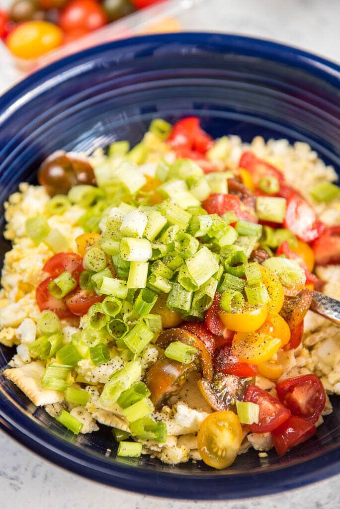 Saltine Cracker Salad may sound unusual but is so easy and delicious! Hard boiled eggs, saltine crackers, tomatoes and mayo form the base of your new favorite side dish!