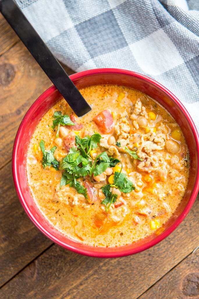 top view of buffalo chicken chili in red bowl with black spoon