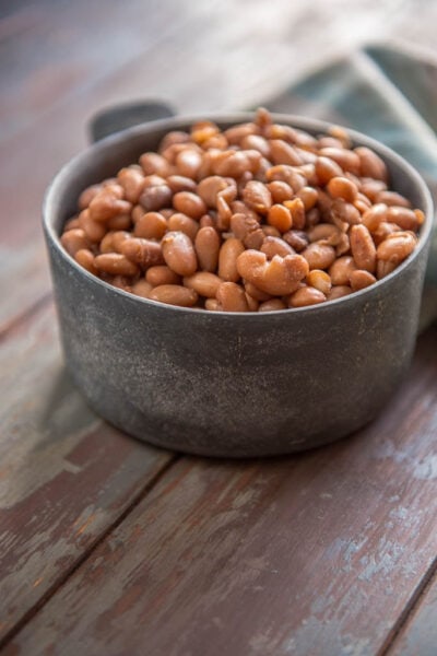 Slow Cooker Pinto Beans in metal bowl on painted table