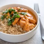 Instant Pot Chicken Tikka Masala in white bowls with brown rice and cilantro