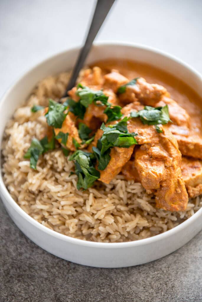 Instant Pot Chicken Tikka Masala in white bowls with brown rice and cilantro